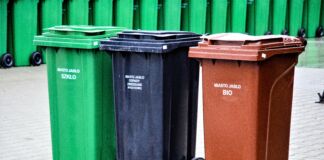 trzy pojemniki na odpady - zielony, czarny i brązowy