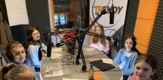 Wizyta w studio radia, stół, mikrofony a przy nim dzieci - zespół projektowy w Radiu Trendy