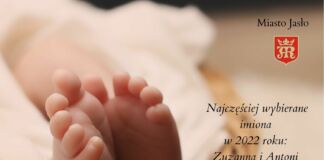 Plakat, małe stopy dziecka owinięte w pieluszkę w koszyku Miasto Jasło i herb miasta. Najczęściej wybierane imiona w 2022 roku: Zuzanna i Antoni