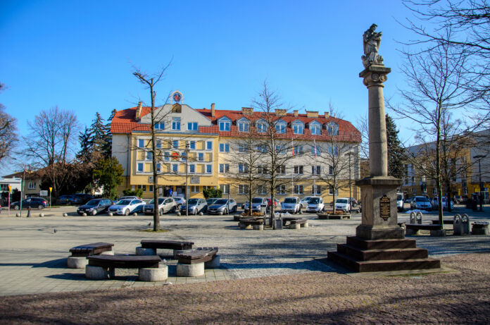front budynku urzędu miasta w Jaśle. Na pierwszym planie widoczny pomnik św. jana nepomucena