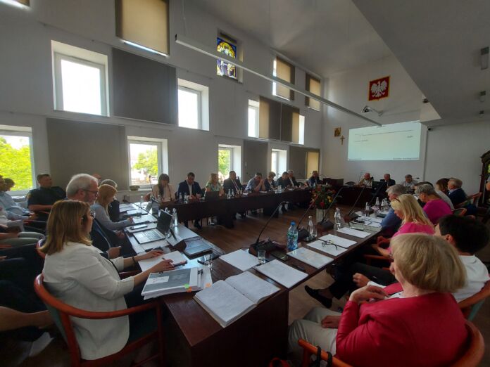 sesja RMJ - radni i zarząd miasta siedzą przy stołach konferencyjnych